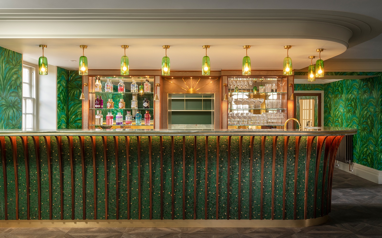 bar counter with green mosaic surface by TREND mosaics and green glass lights above