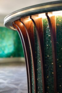 detail of mosaic surface of curved bar in green and gold mosaics