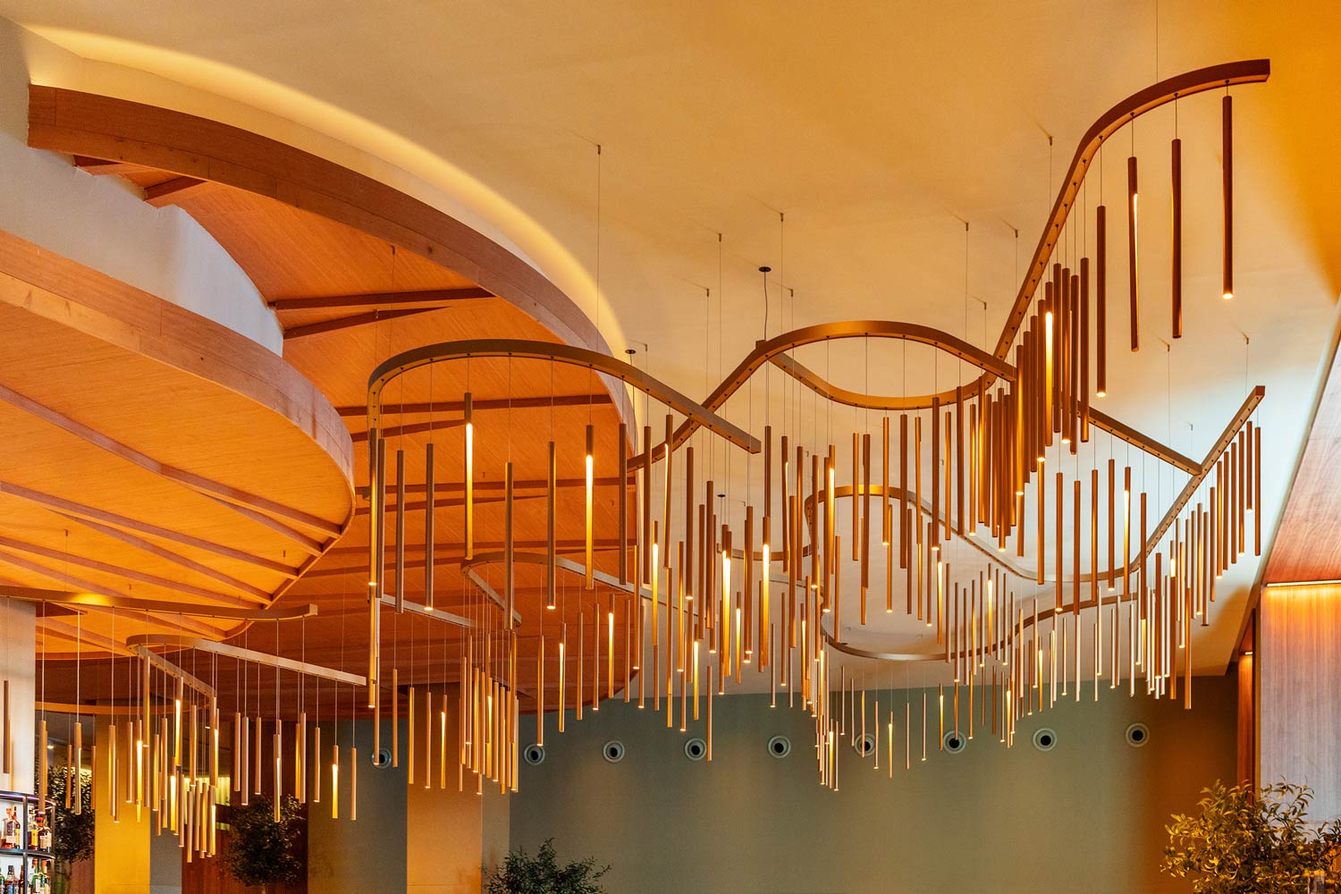 a customised lighting design in a hotel lobby with curved structure supporting metal rods