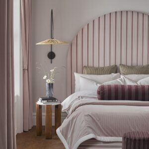 arched headboard covered in pink stripes from the Whitworth fabric portfolio