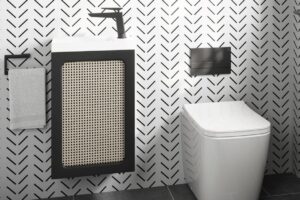 black and white arow pattern wallcovering behind small cloakroom basin and wall hung unit in ALO range from Crosswater