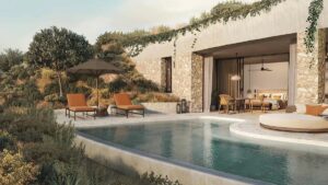view of private villa with stone finishes from across pool in mandarin oriental costa navarino