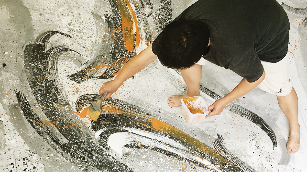 A man painting onto a large surface area