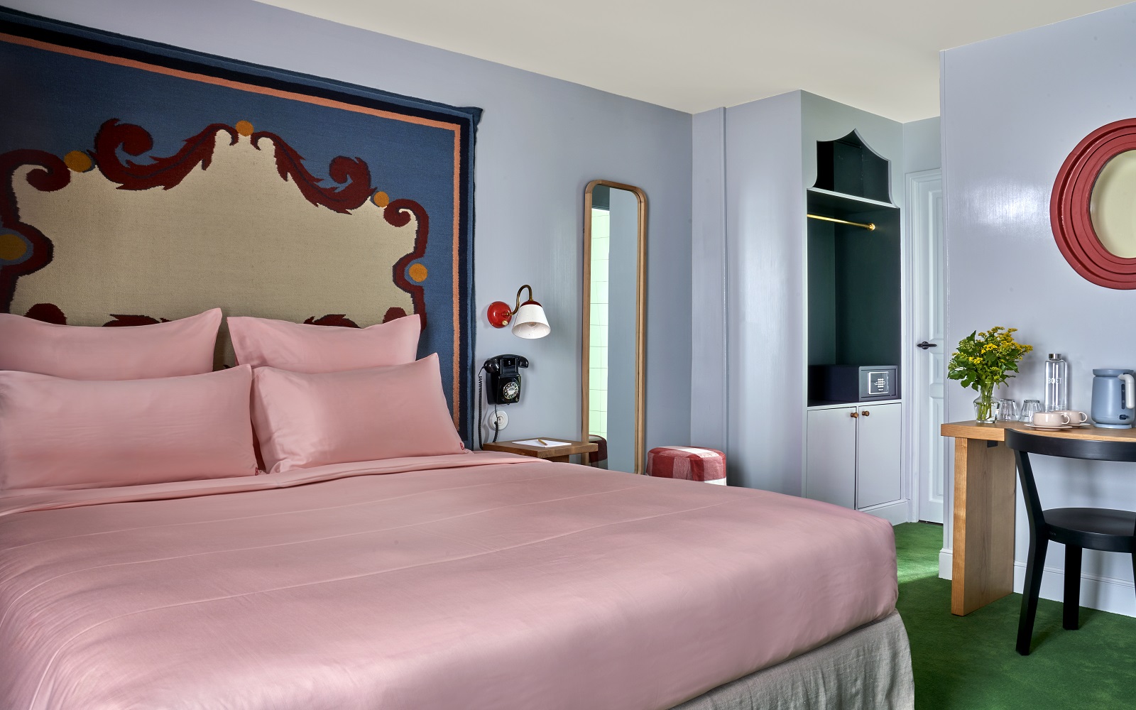 colourful guestroom at Hotel de la Boetie with pink bed linen blue patterned wall and green carpet