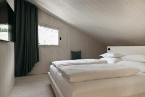 simple bedroom with wood cladding and white linen in Atto suites