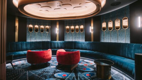 dark interior of bar with focus lighting over bespoke modieus carpet in blue and red in casino