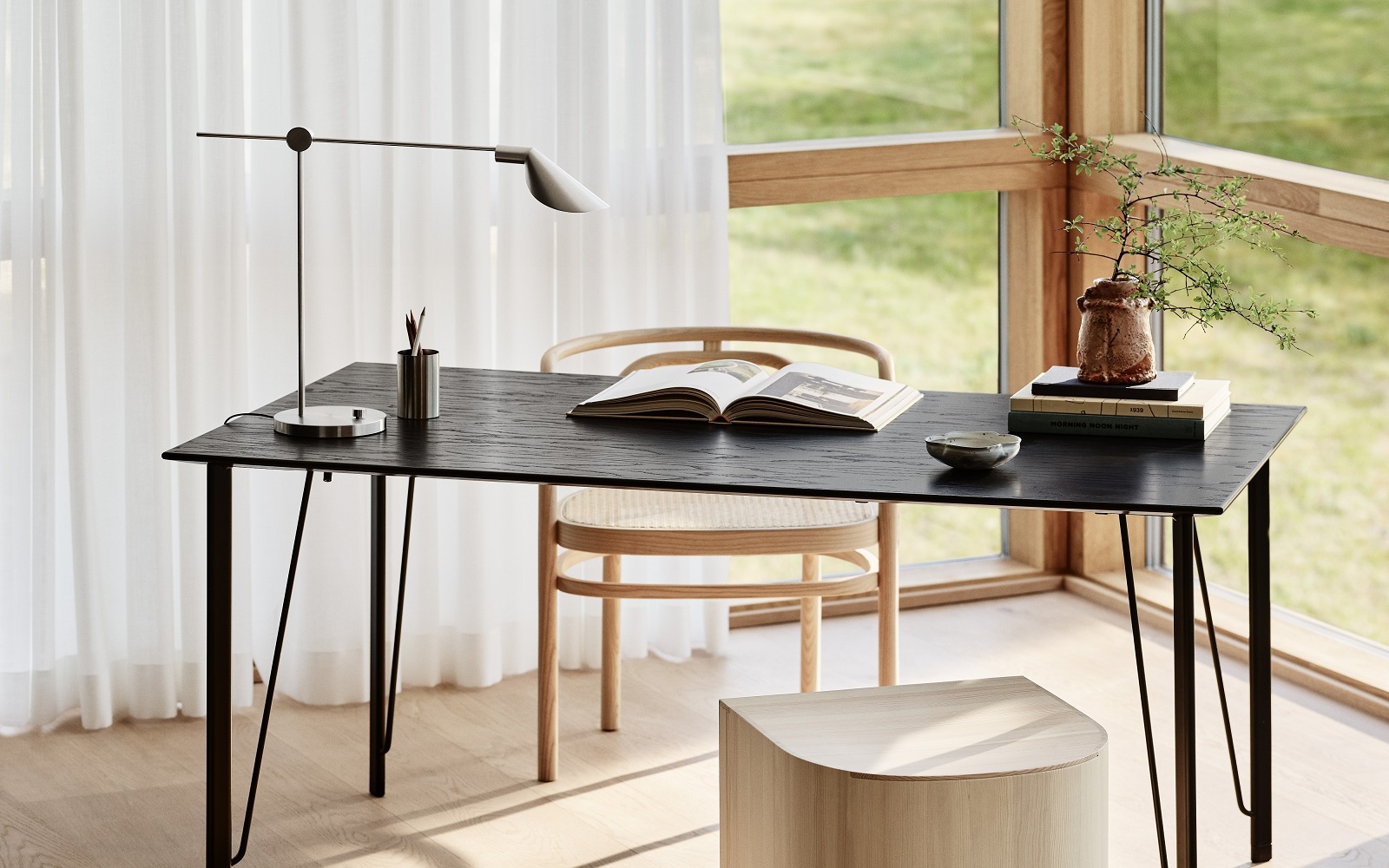 minimalist table as a desk with open book and MS lamp from Fritz Hansen in front of a window