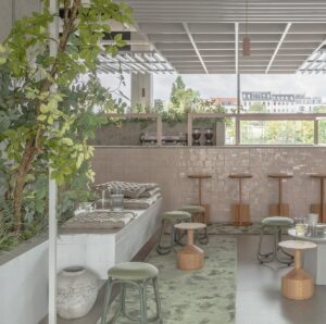green carpets and cream tiled surfaces with cascading plants in the restaurant in Berlin