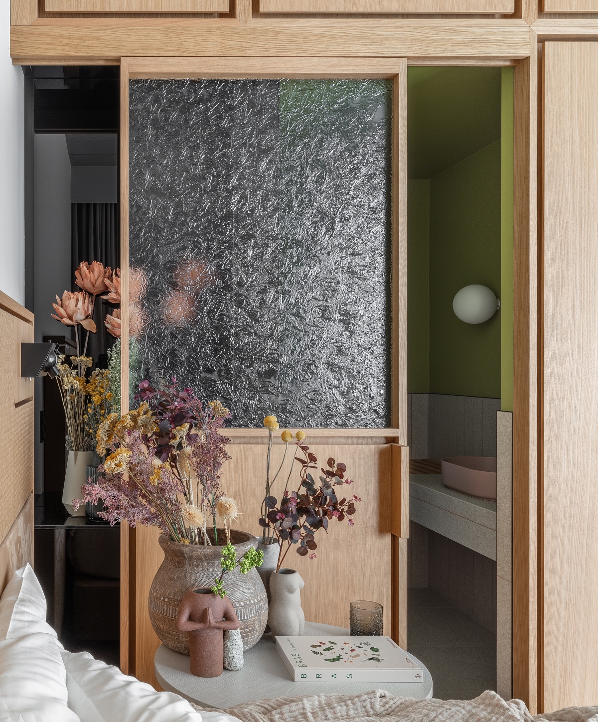 textured glass and wooden panels between the bathroom and the guestroom