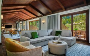cream couches and chairs under a wooden beamed ceiling in mountain resort with alpine views 