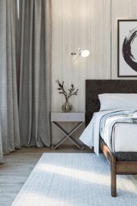 monochromatic bedroom design in grey and black and white with x leg bedside table and black and white abstract painting on the wall