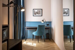 wooden floor, blue wall with wood detail and blue furniture and vintage lighting in Stadt Hotel Città