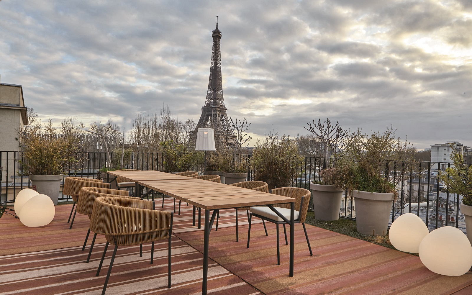 outdoor table and chairs from Ligne Roset on a wooden deck in Paris with view to Eiffel Tower