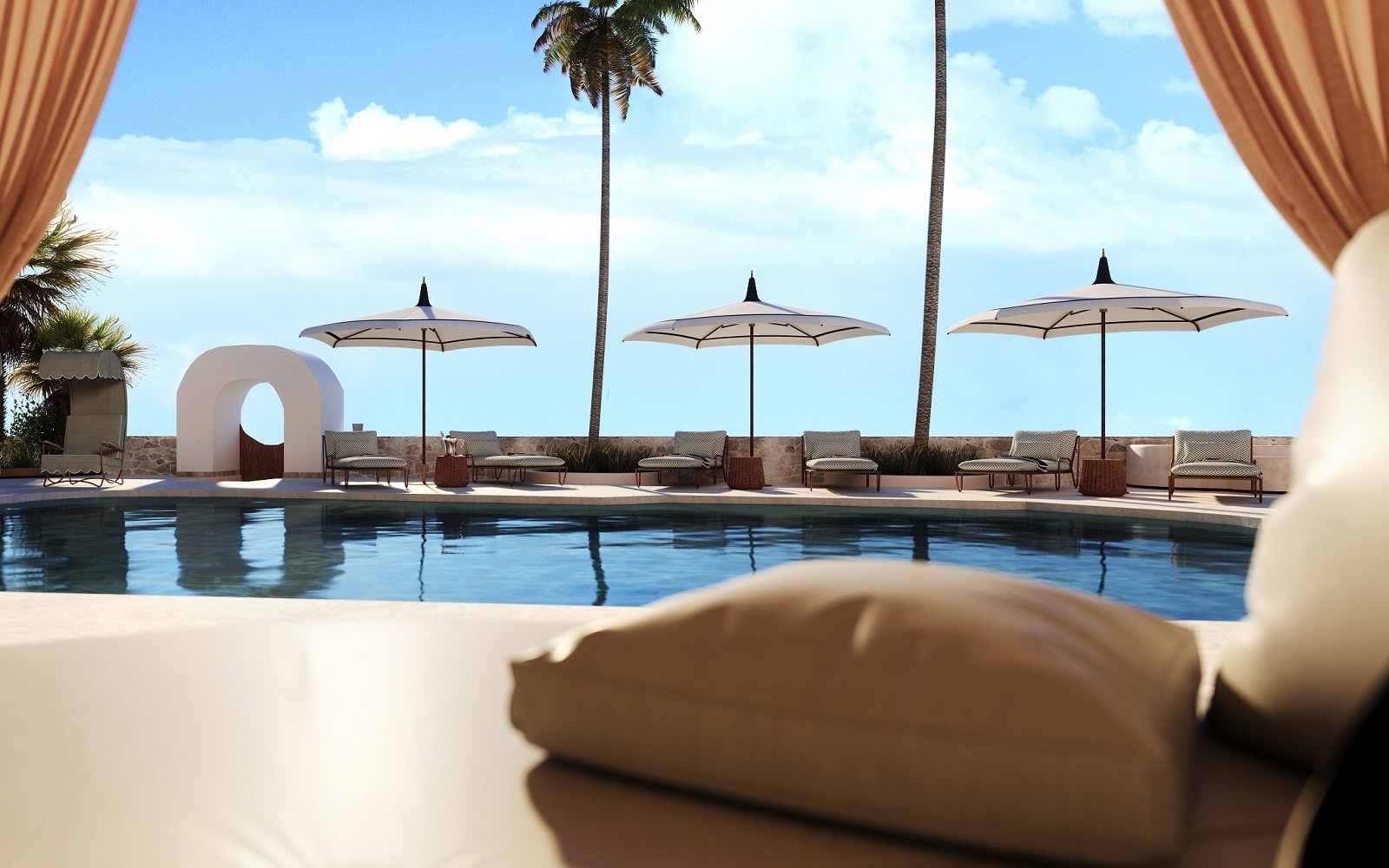 view from cushioned seating across pool to umbrellas and views across Ibiza