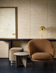 brown chair, table and stool in front of wall in natural shades and textures of raffia