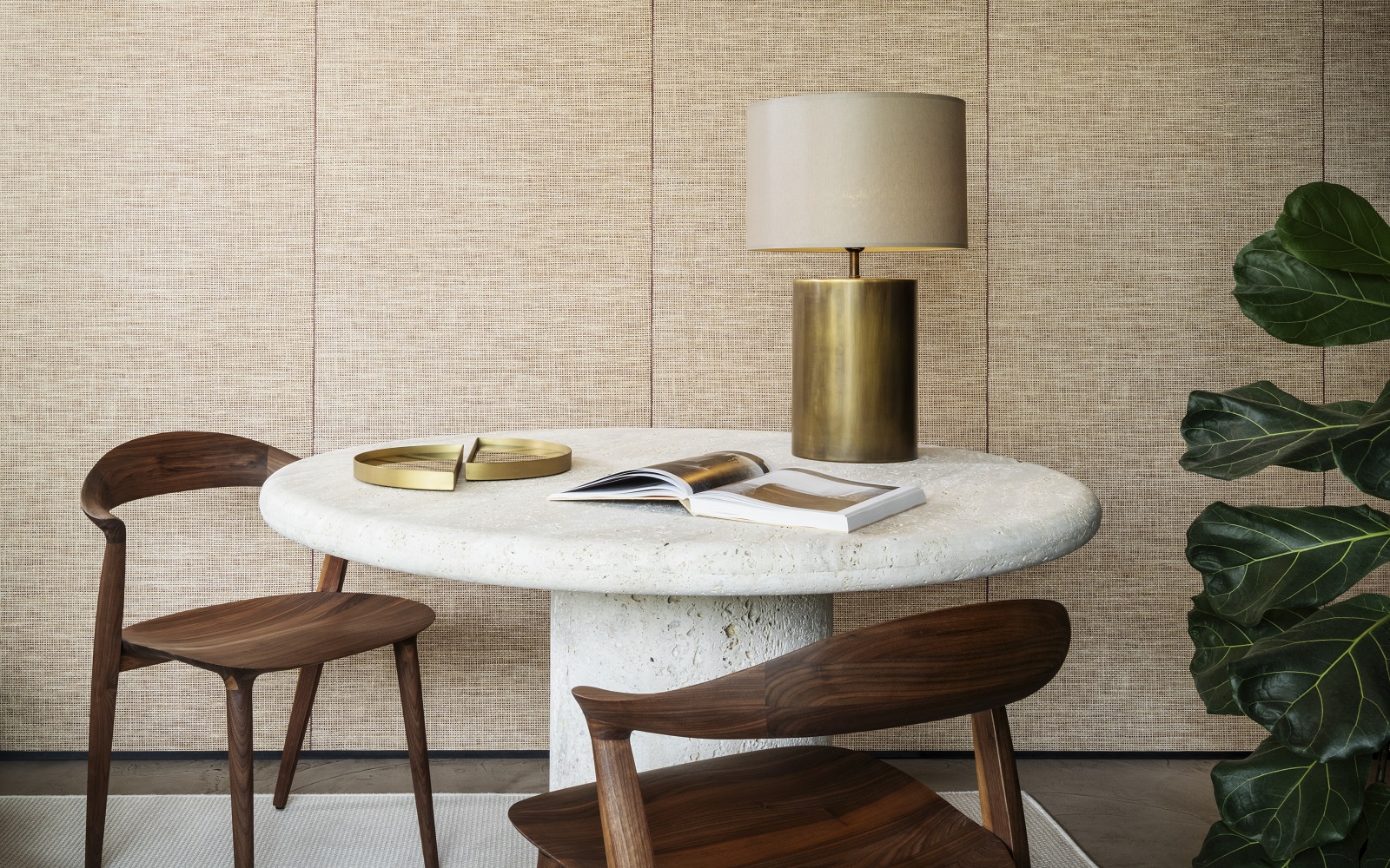 wooden chairs around a stone coloured organic shaped table in front of natural raffia textured wallcovering from Arte