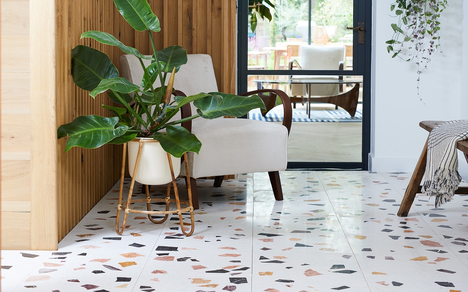 entrance hall with chair and plant and Bert & May course terrazzo style tiles on the floor
