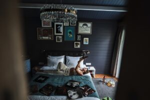 guestroom in Oaga Maldives with moody dark walls and a statement chandelier with art on the walls