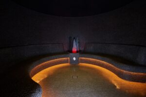volcanic steam room with curved seating and low lighting in the spa at center parcs