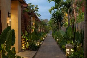 paths lit by lanterns and surrounded by tropical plants past the villas at Garrya Bianti Yogyakarta hotel