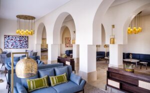 blue couches in front of arches with ornamental brass lighting in the lobby of The Residence Douz