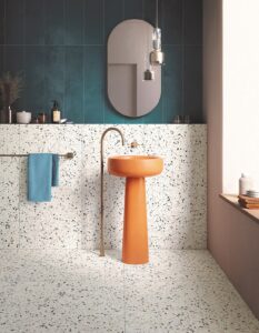 bathroom with terrazzo style tiles on floor and wall, orange basin and blue wall
