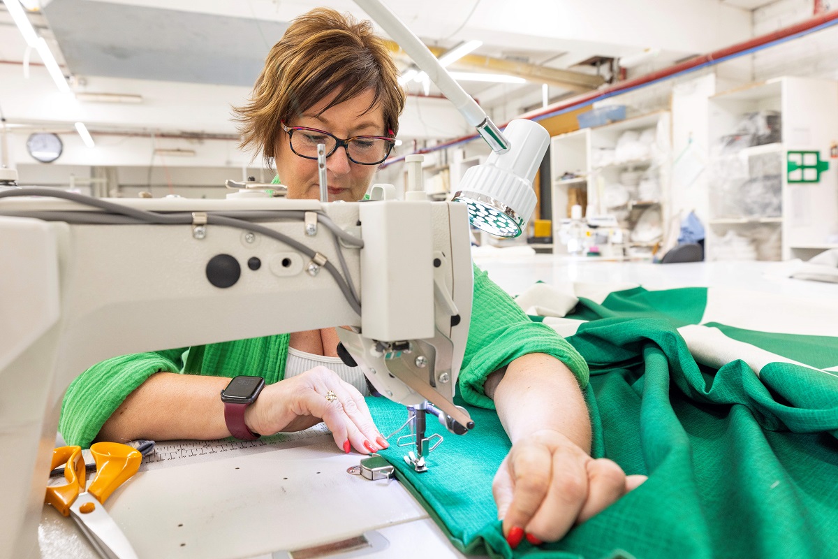 woman sewing fabric in showroom