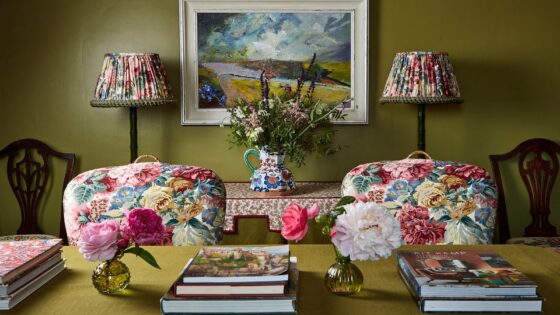floral fabric on chairs behind desk and lampshades in florals with sanderson trim against olive green wall