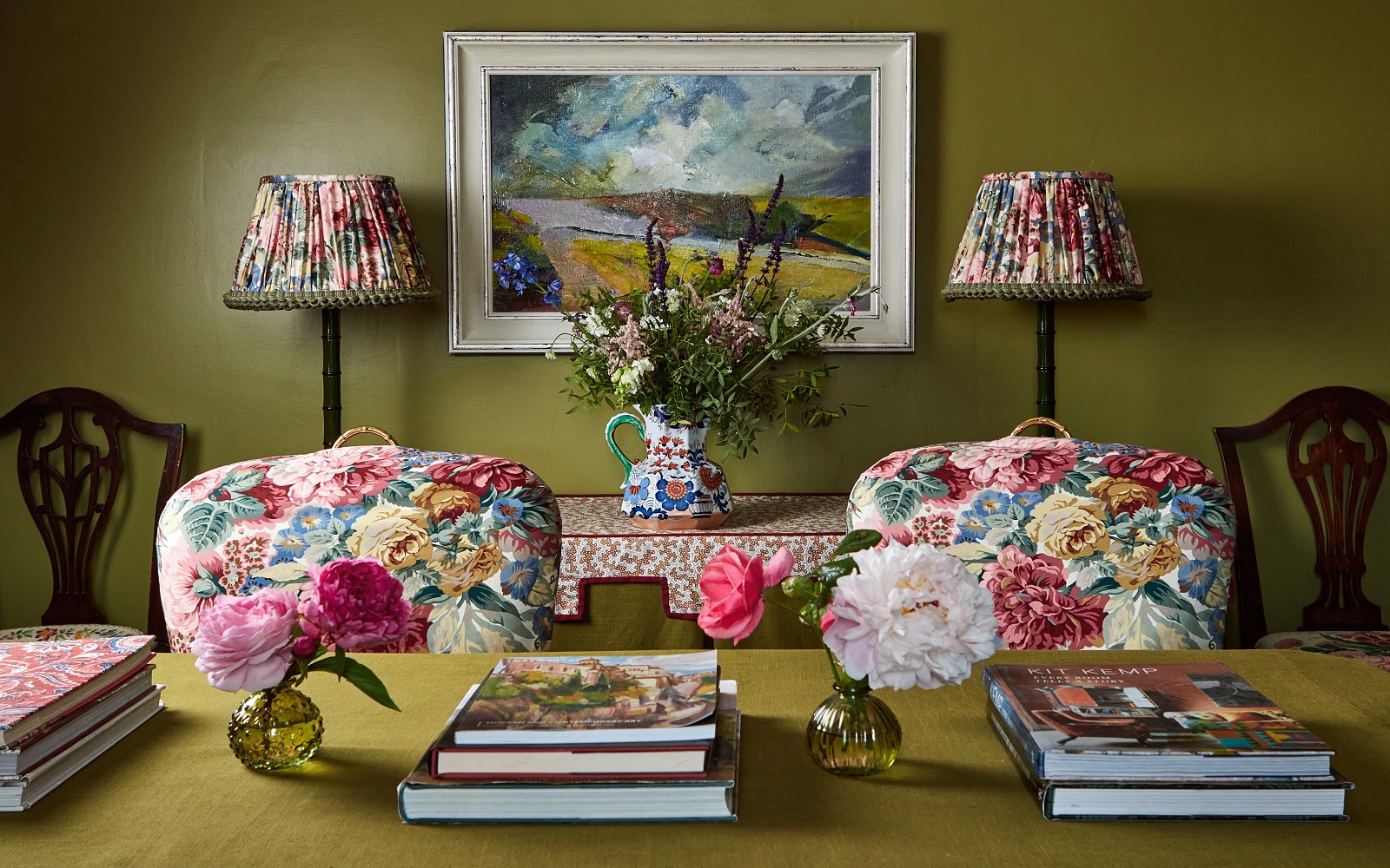 floral fabric on chairs behind desk and lampshades in florals with sanderson trim against olive green wall