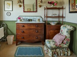 country style bathroom with wooden dresser and chair upholstered in floral with patterned cushion