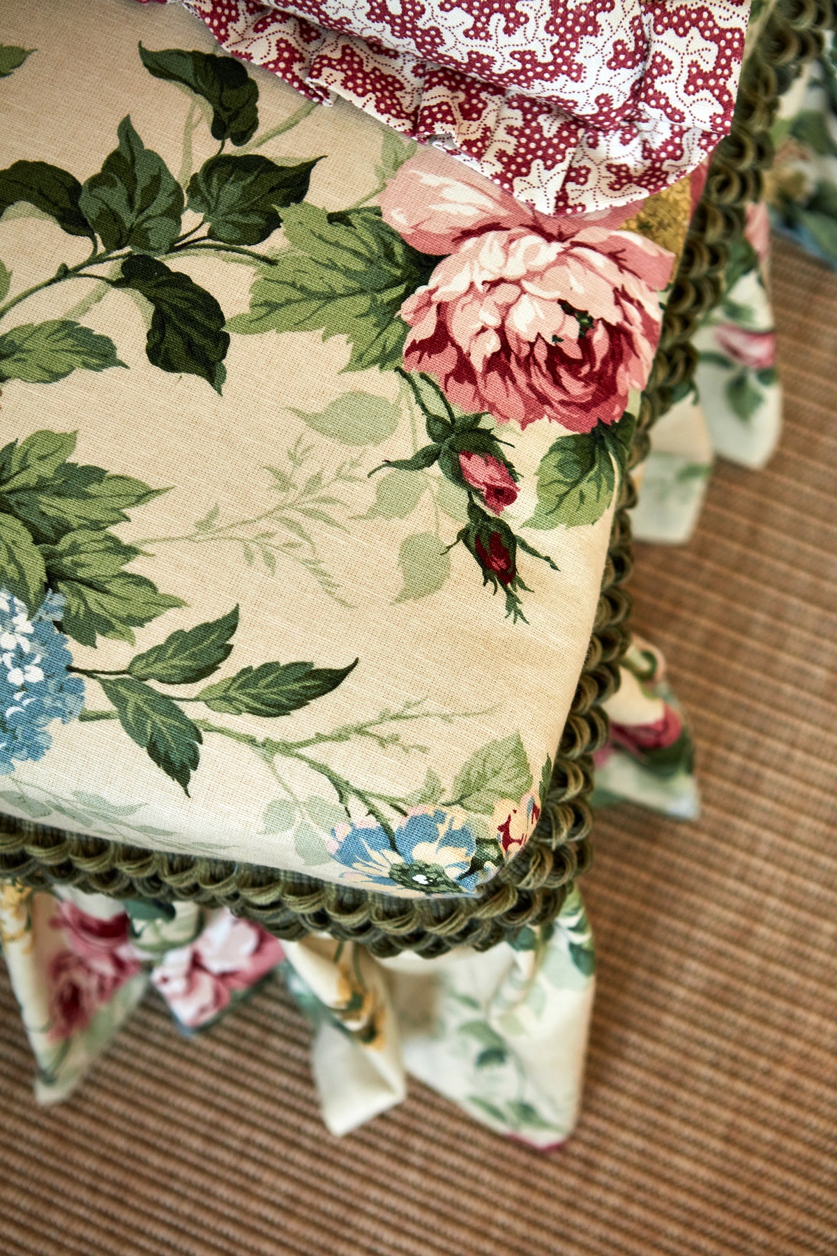 close up of corner of a chair in floral fabric and braided trim