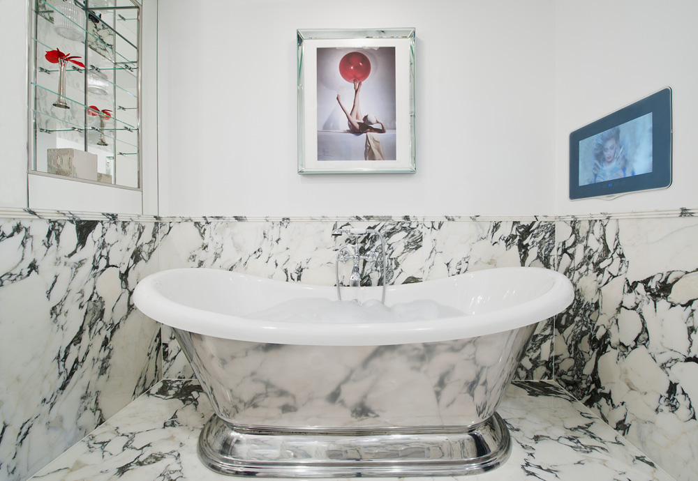 A luxury, freestanding bath with half marble stone wall surface covered