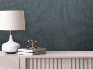 grey wallcovering inspired by oxford cloth behind a cream console and a white lamp