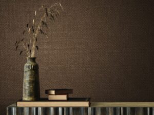 natural coloured raffia style wallcovering with ceramic vase and dried grasses on a wooden table