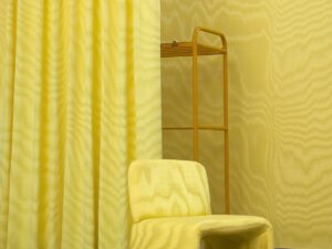 yellow Dedar fabric on chair with curtain and wallcovering in yellow cubicle