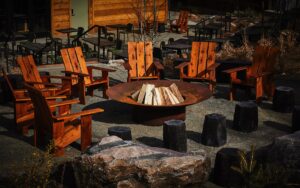wooden Adirondack chairs around a central firepit