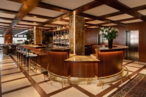 bar and lobby area of Parisian hotel with curved wooden bar and marble floor