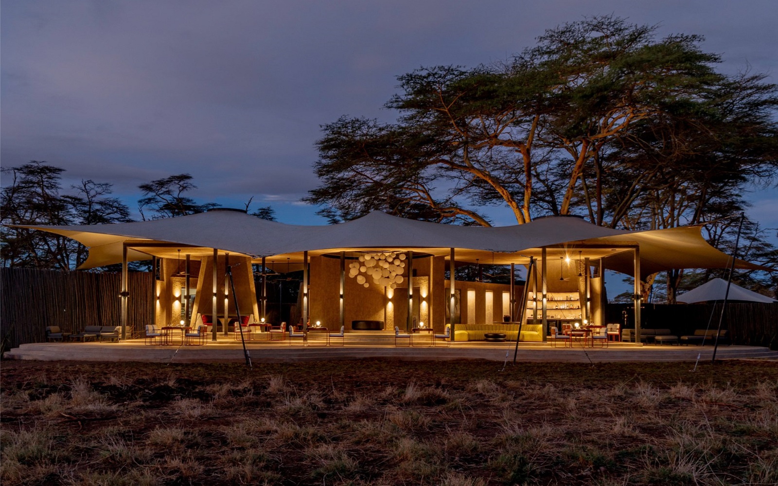 tented safari camp and thorn trees at dusk at Angama-Amboseli Kenya