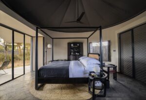 modern black four poster bed in a tented guestroom in Kenya