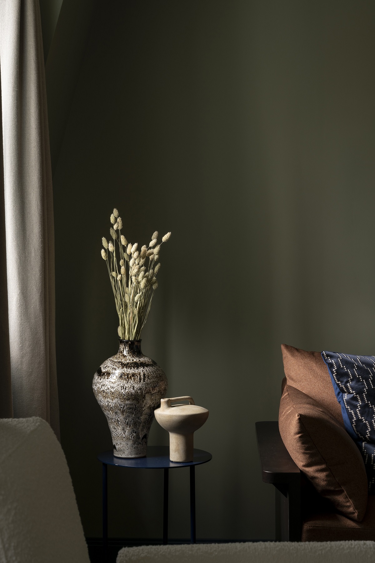 ceramic vases and leather couch against dark grey wall