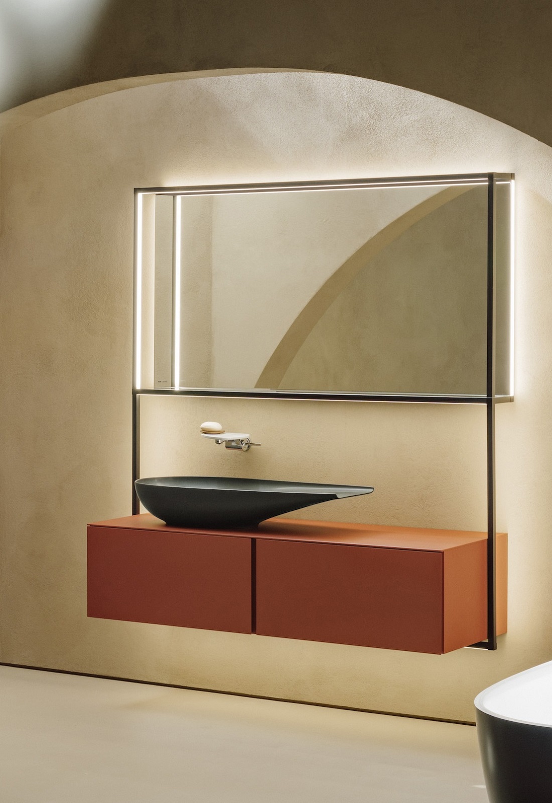 black basin on orange vanity unit with square mirror above