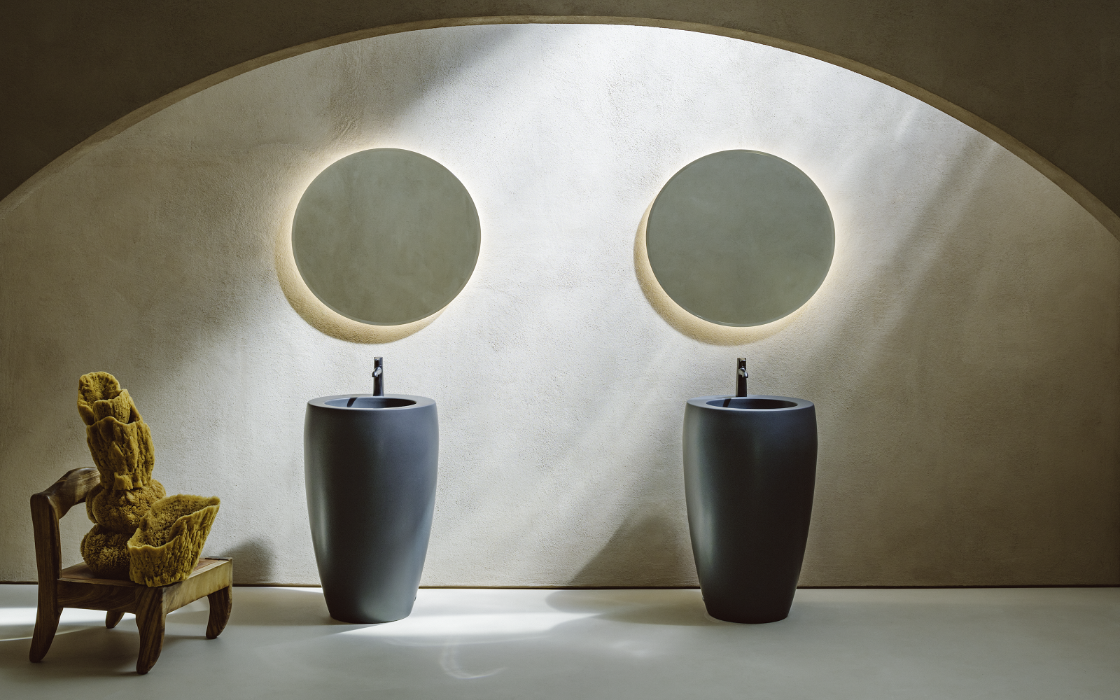 two round wall mirrors above two frreestanding basin units from Laufen