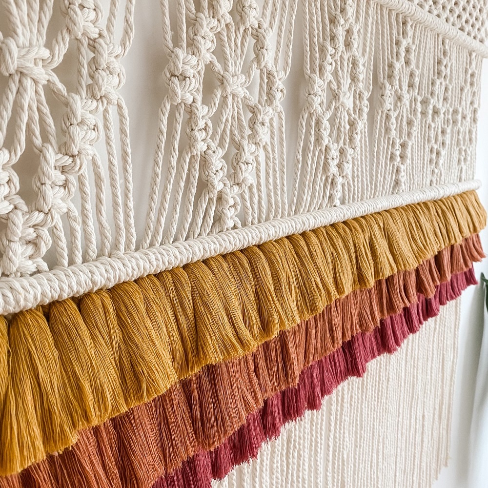 macrame wall hanging with fringing detail in shades of terracotta
