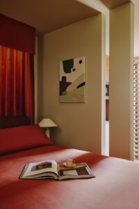 corner of guestroom in Locke Zurich with an open book on the bed