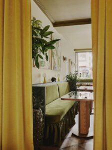 mustard curtains and green velvet banquettes in Locke Zurich