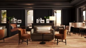 leather chairs, wooden floors and dark walls in the seating and bar area of the hotel