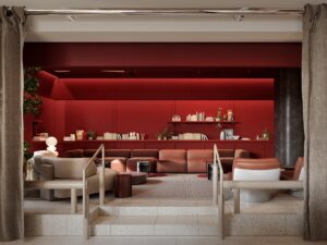 A red wall behind a cream interior with soft seating at The StandardX Melbourne
