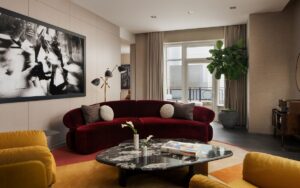 curved rust couch next to mustard chairs with black and white statement art in four seasosn suite designed by Bill Rooney