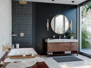 bath and vanity unit with large round mirror on black wall and wood surfaces