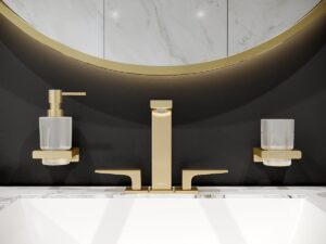 close up image of metropole gold taps with round mirror above basin
